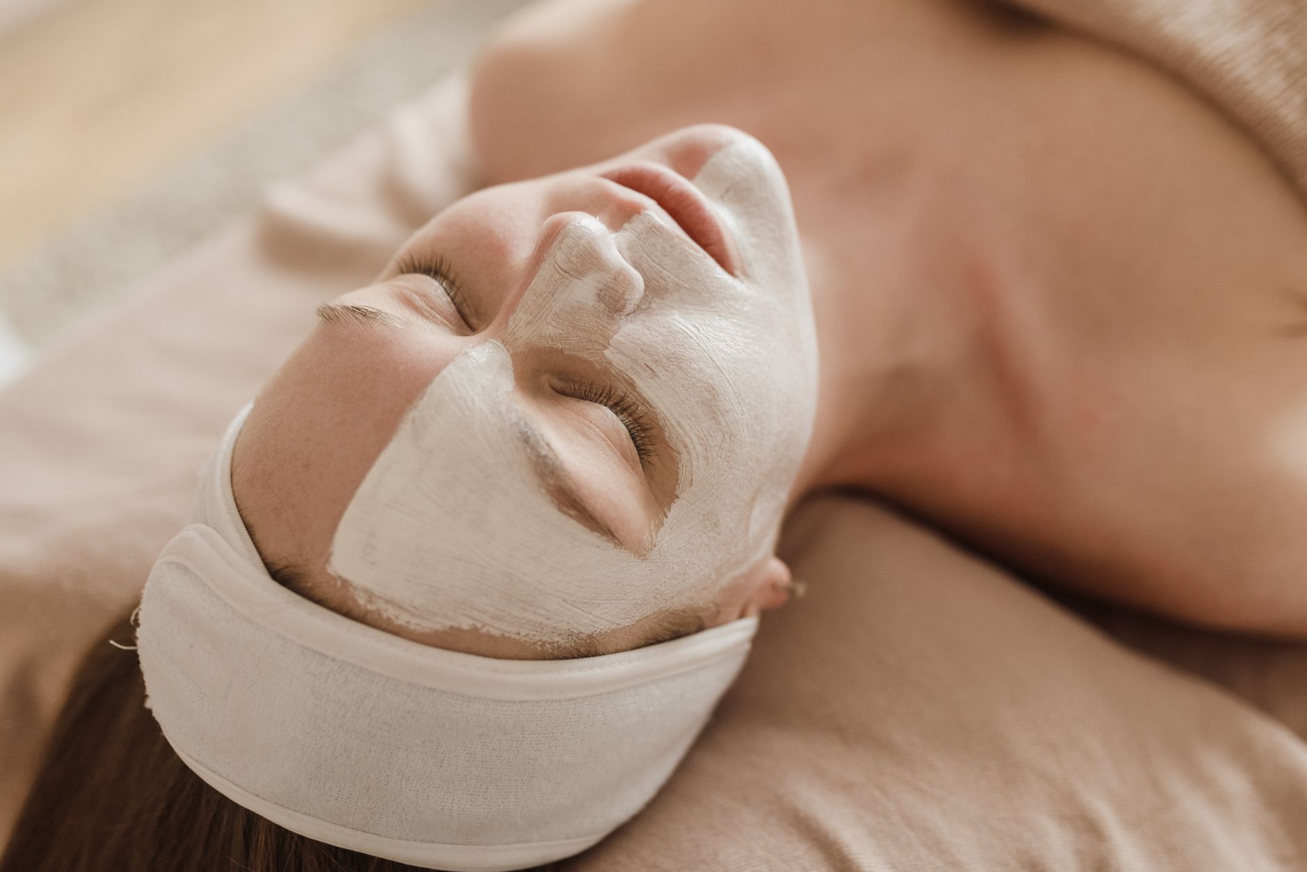 Guest resting under a clay facial mask with a soft headband