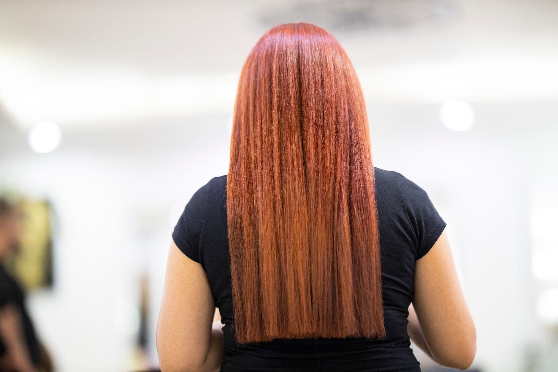 Guest showing glossy, straight copper-red hair after a global colour